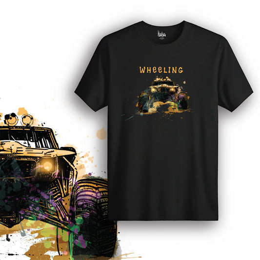 Wheeling T-Shirt (Black) – Rugged rock crawler T-shirt featuring a bold off-road vehicle design with splatter art and “Wheeling” text.